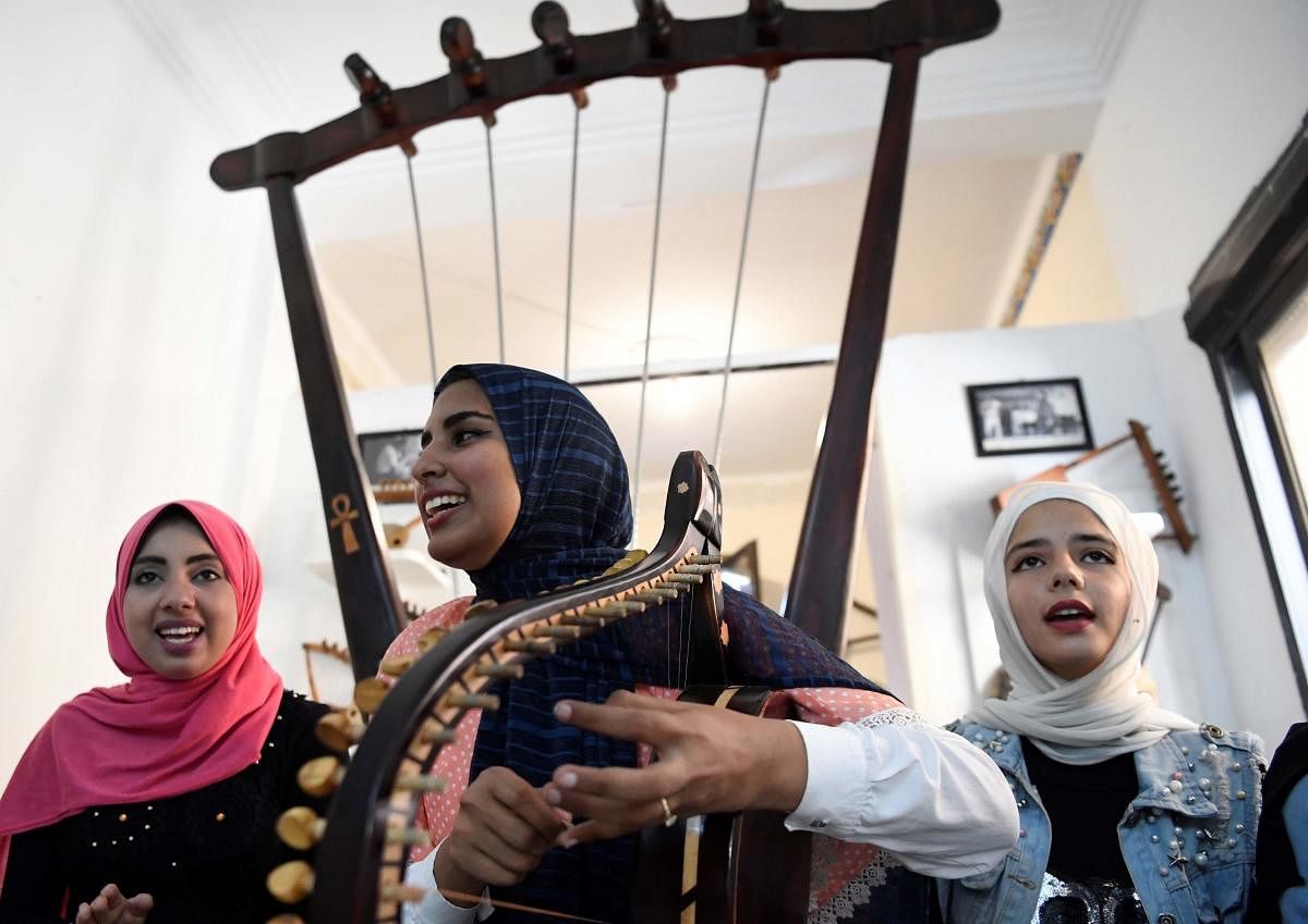 Iman Haddo plays a semsemia fan during a music session at the Canal 20 cultural museum in the northeastern city of Port Said. (AFP Photo)