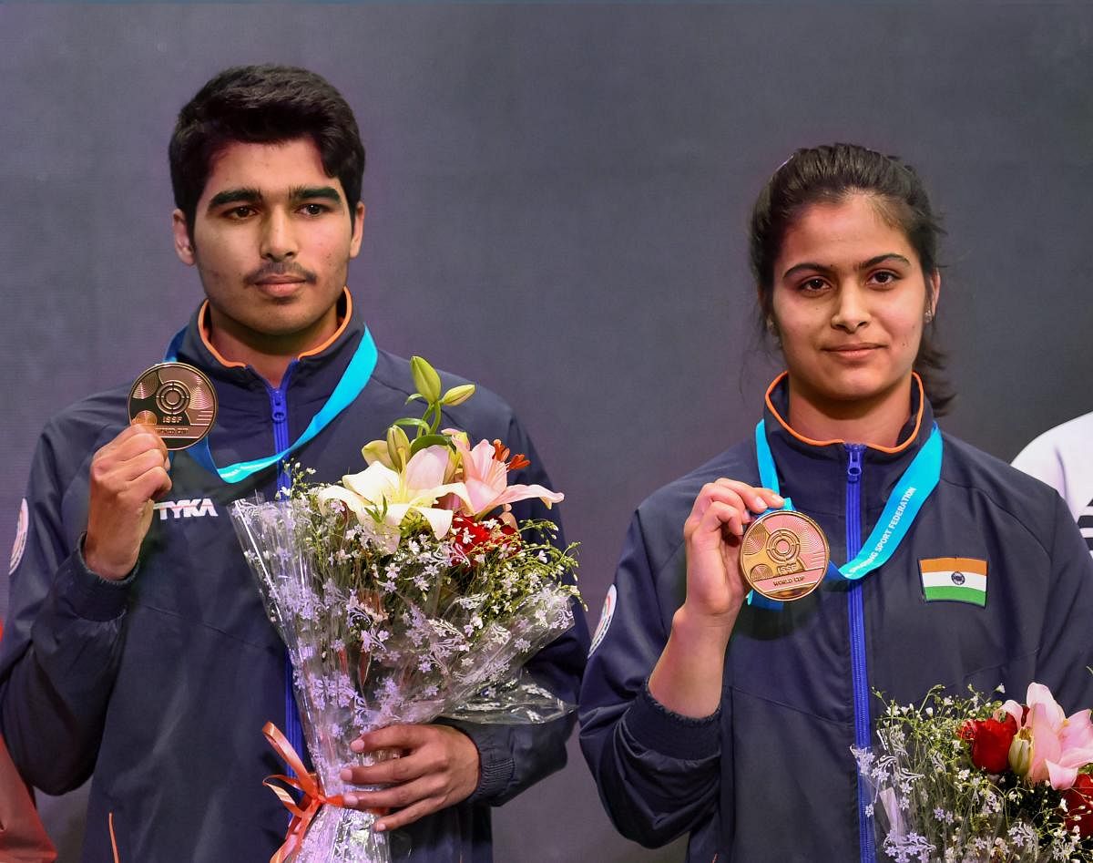 India's Saurabh Chaudhary and Manu Bhaker with their gold medals after winning the 10m air pistol mixed team event at the ISSF World Cup in New Delhi on Wednesday. PTI