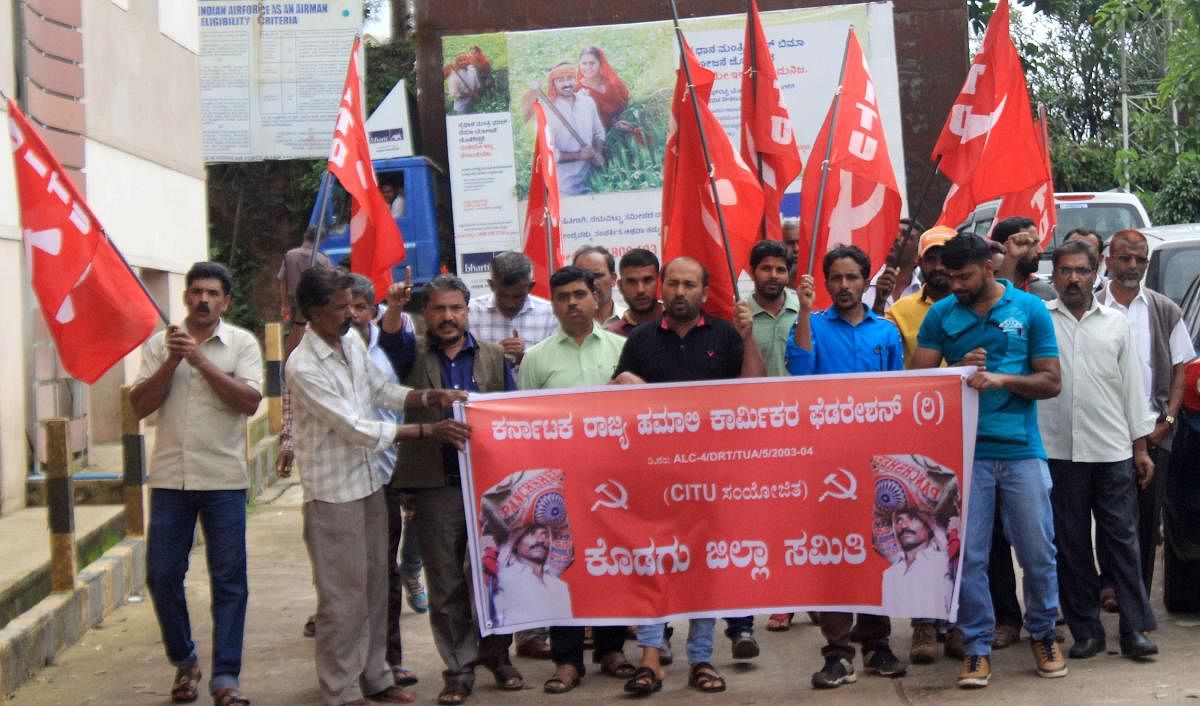 Members of Karnataka State Hamali Workers' Federation stage a protest in front of the deputy commissioner's office in Madikeri on Friday.