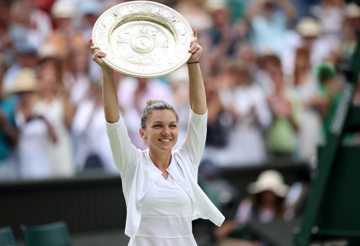 Romania's Simona Halep poses with the trophy as she celebrates after winning the final against Serena Williams of the U.S. REUTERS
