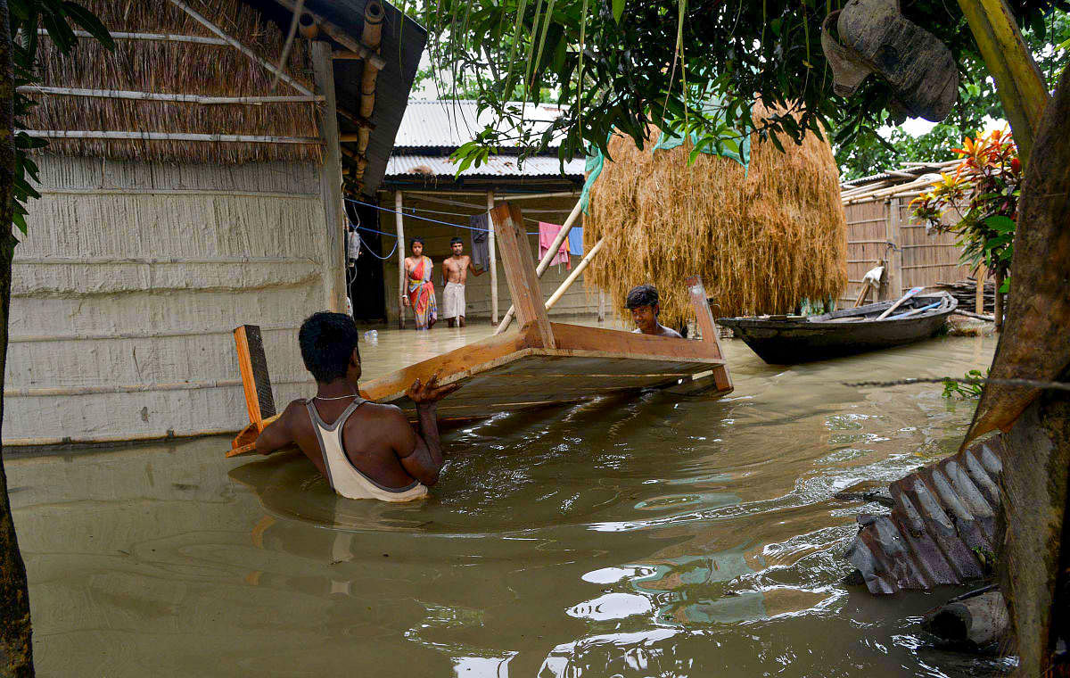  Flood-affected people shift to safer places from a village in Morigaon district of Assam on Sunday. PTI photo