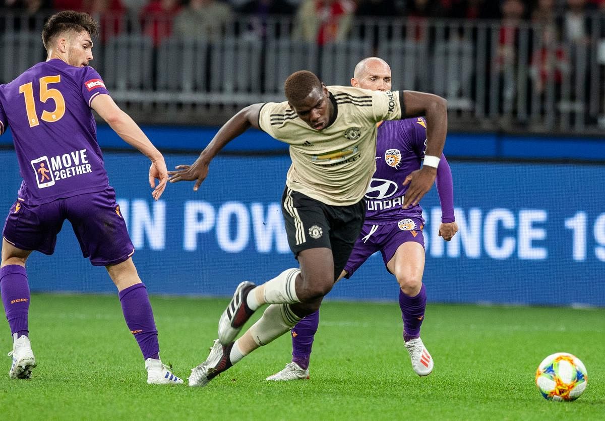 Manchester Paul Pogba (C) fights for the ball with Perth Glory's Chris Harold (L) and Gabriel Popovic (R) during their pre-season friendly match at Optus Stadium in Perth on July 13, 2019. TONY ASHBY / AFP