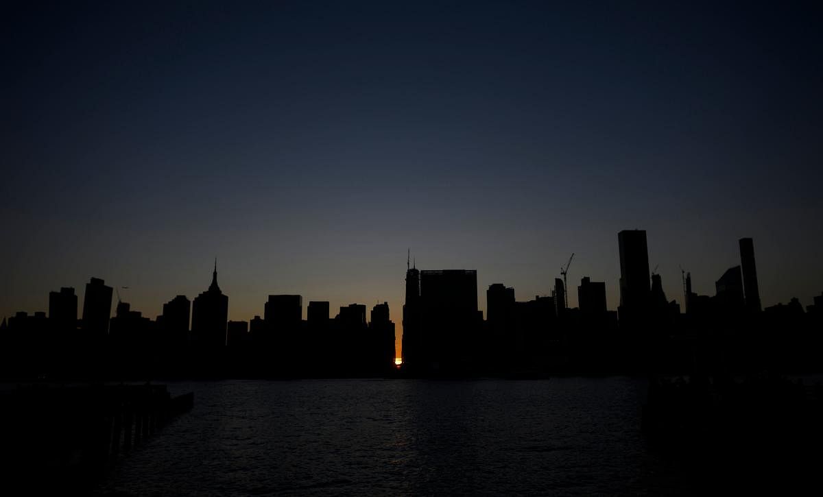 The sun sets behind 42nd Street in Manhattan during a power outage in New York City on July 13, 2019. - Subway stations plunged into darkness and the billboards of Times Square suddenly flicked off as New York's Manhattan was hit by a power outage on Satu