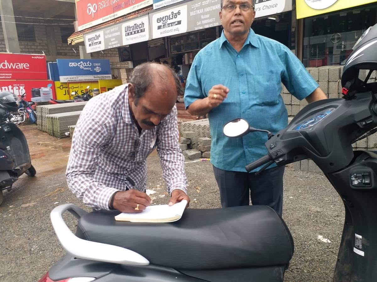 Officials of Mangaluru City Corporation collect fine from those who had dumped waste on the road in Mangaluru.