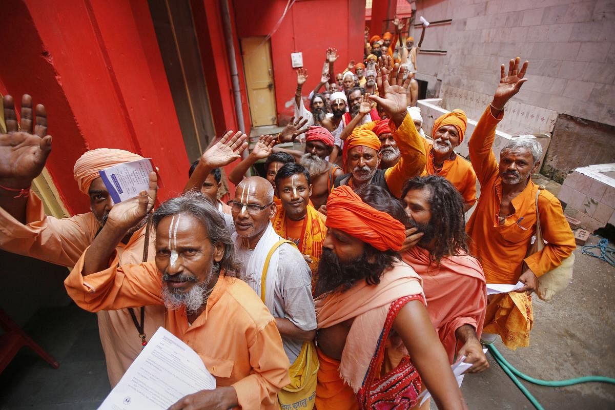 Pilgrims chant religious slogans as they stand in a queue to get themselves registered for Amarnath Yatra, at Ram Mandir base camp in Jammu, Friday, July 12, 2019. (PTI Photo)