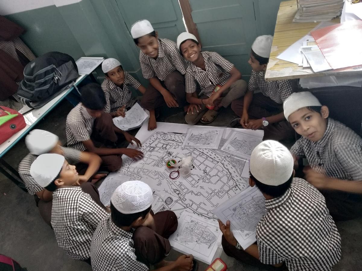 Students at the RMES School find places in an old map of Bengaluru city as part of an activity organised by Intach. Special arrangement