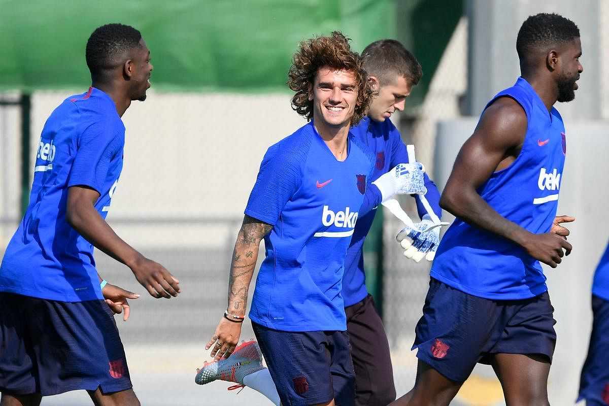 Barcelona's French forward Antoine Griezmann laughs as he runs during the football club's first pre-season training session at the Joan Gamper training ground in Sant Joan Despi near Barcelona on July 15, 2019. (AFP)