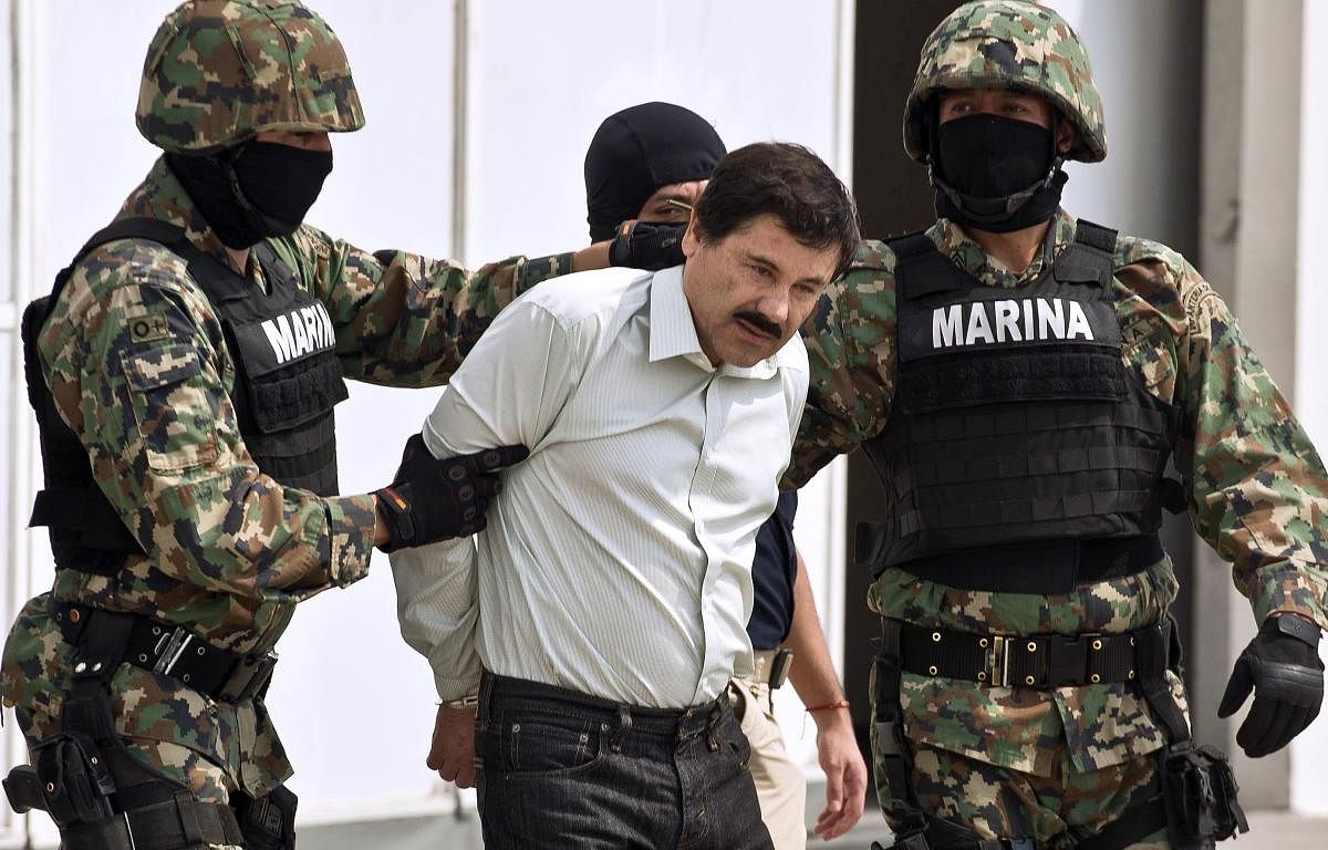 Mexican drug trafficker Joaquin Guzman Loera aka 'El Chapo Guzman' (C), is escorted by marines as he is presented to the press in Mexico City in 2014 (AFP File Photo)