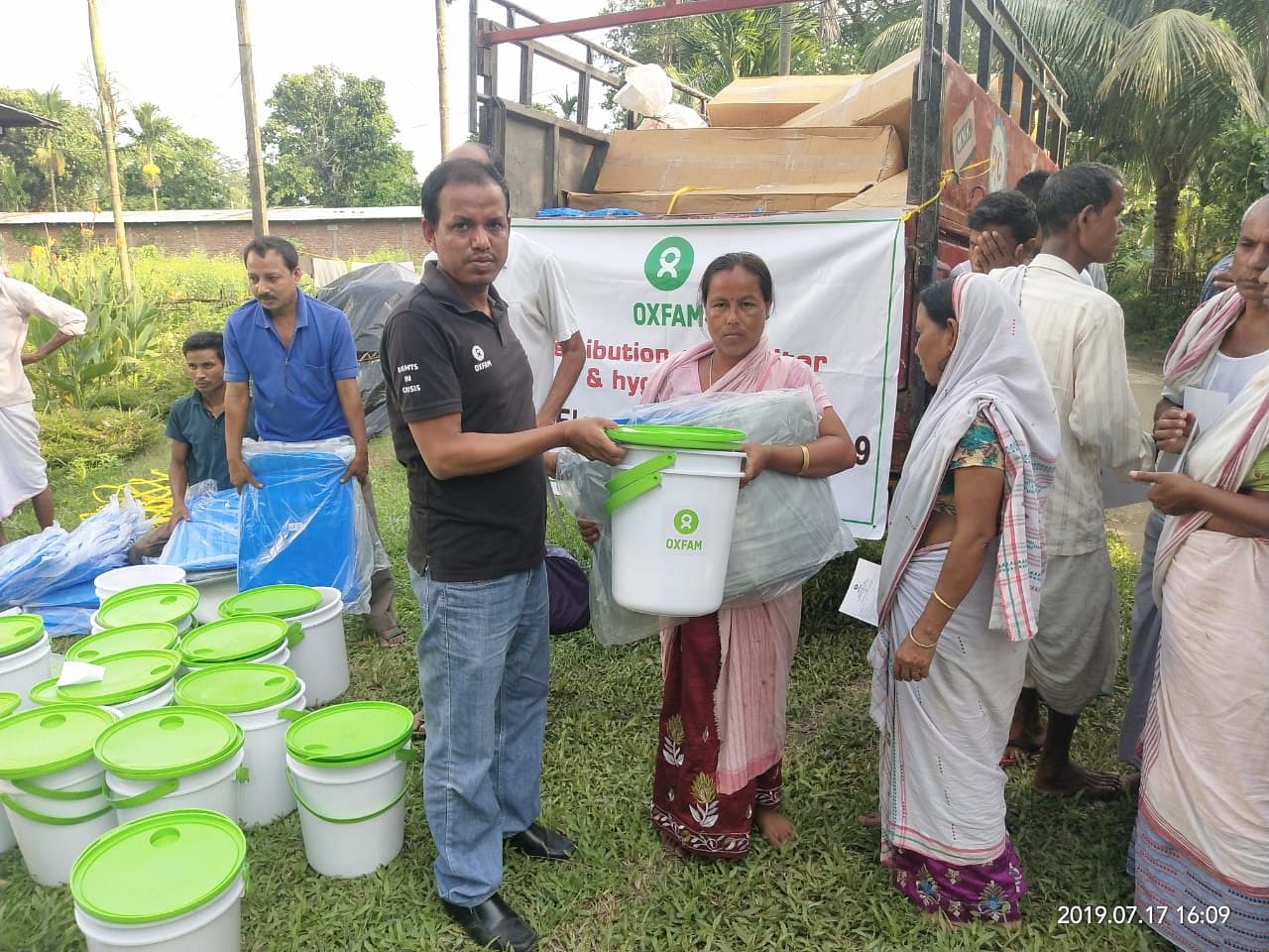 Oxfam India distributing relief materials among flood hit people in Lahorighat area in upper Assam on Wednesday. DH photo