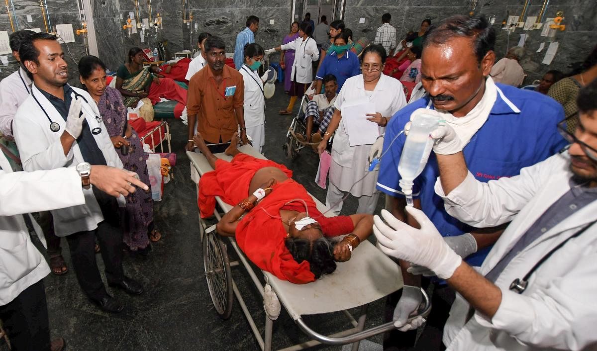 A woman is shifted to a hospital in as she complained of sickness after consuming 'prasad' at Maramma temple in Chamrajanagar district, in Mysuru, Friday, Dec 14, 2018. At least five people died and 40 others fell sick due to suspected food poisoning after consuming 'prasad' at the temple. (PTI Photo)