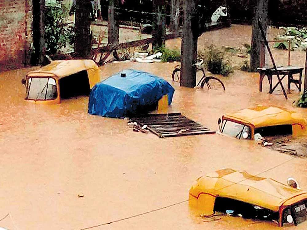 BELOW WATERLEVEL: Vehicles submerged in flood water following a heavy downpour at Dhobinala in Dimapur, Nagaland, on Wednesday. PTI