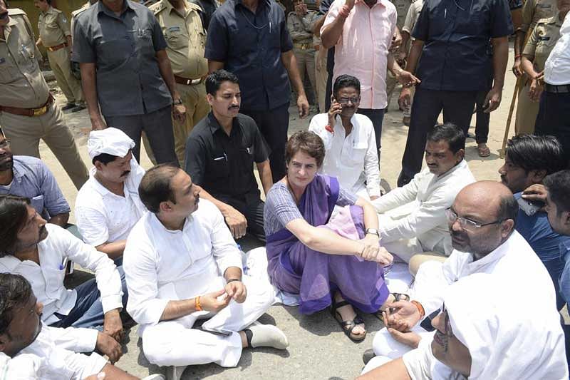 Congress General Secretary Priyanka Gandhi Vadra sits in protest on the roadside, after she was stopped from proceeding to Sonbhadra to meet victims of clash that claimed 10 lives, in Mirzapur. (PTI Photo)