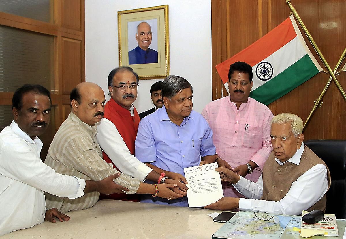 BJP leaders Jagadish Shettar (C), Arvind Limbavali (3rd L) and others submit a letters to Karnataka Governor Vajubhai Vala (R) during a meeting at Rajbhavan, in Bengaluru on Thursday. PTI photo