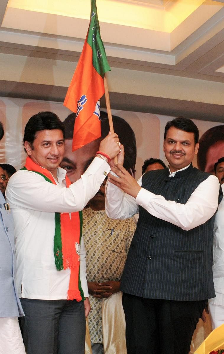 Maharashtra Chief Minister Devendra Fadnavis and former NCP MP Ranjitsinh Mohite Patil hold the BJP flag after the latter joined the party, in Mumbai on March 20, 2019. PTI