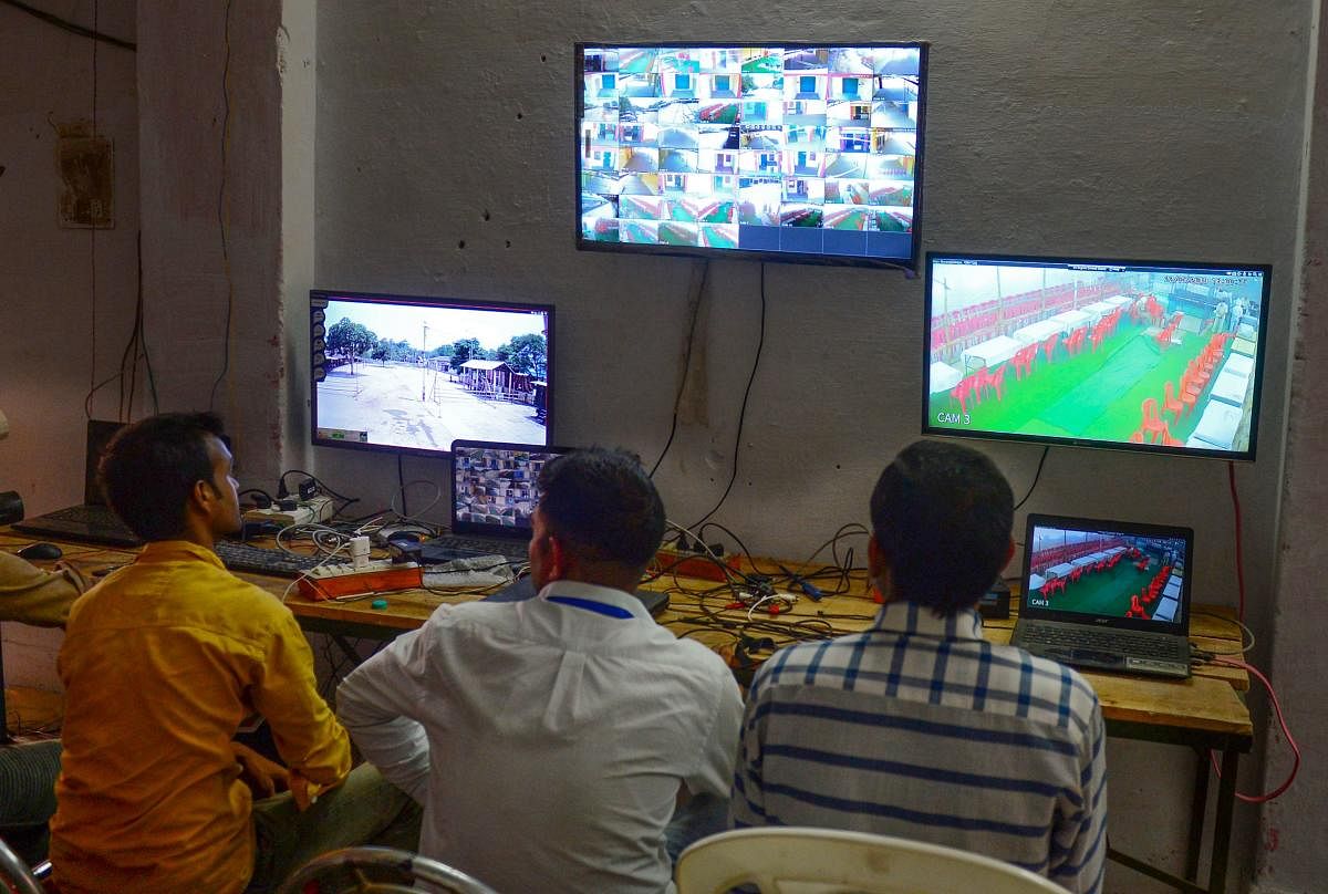 Counting agents of different political parties observe CCTV footage inside a vote counting centre where Electronic Voting Machines (EVM) is being kept on the eve of the counting day in India's general election. (Photo by AFP)