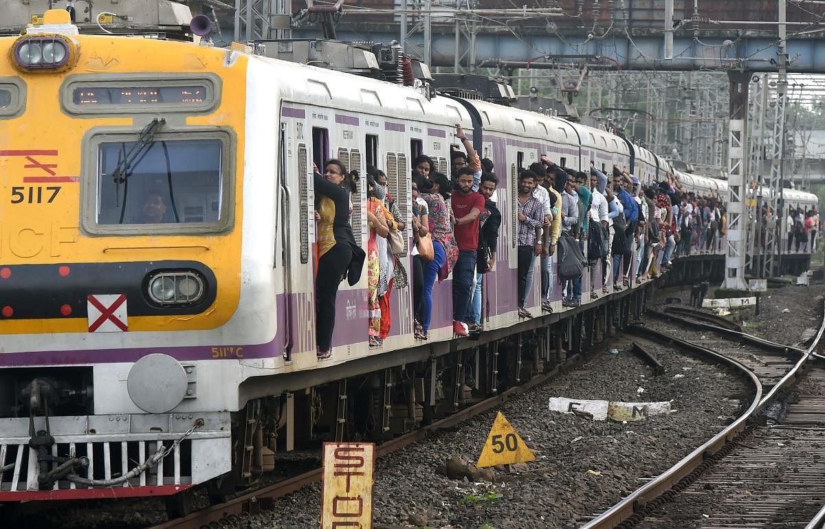 A crowded local passenger train approaches a platform in Mumbai on July 5, 2019. (Photo: AFP)