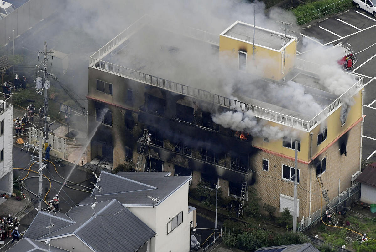 An aerial view shows firefighters battling fires at the site where a man started a fire after spraying a liquid at a three-story studio of Kyoto Animation Co. in Kyoto, western Japan, in this photo taken by Kyodo. Reuters