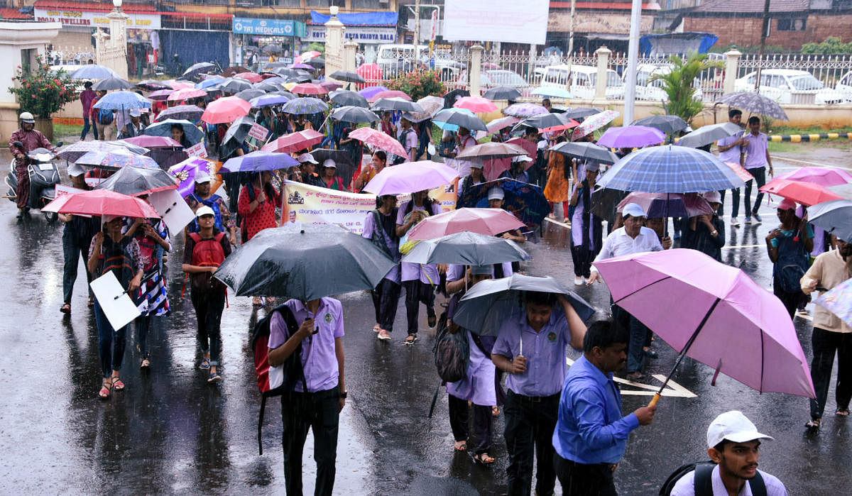 College students take part in a rally, amid rain, organised as a part of 'Swasthya Sankalpa' campaign on the premises of the Town Hall, Mangaluru, on Thursday.