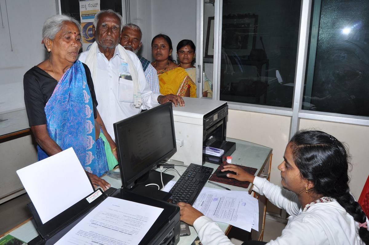 A woman tries to get her biometric registered for Arogya Card, at a Common Service Centre in Mandya.