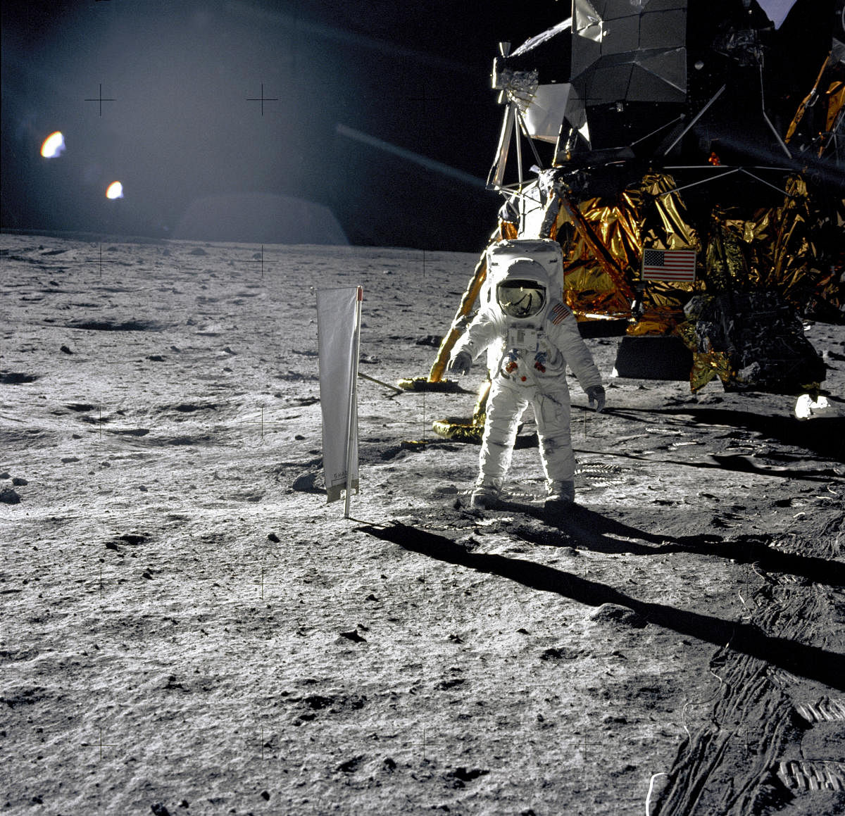 Moonscaped: Astronaut Edwin E. Aldrin, Jr., Lunar Module pilot, is photographed during the Apollo 11 extravehicular activity (EVA) on the lunar surface. In the right background is the Lunar Module "Eagle." On Aldrin's right is the Solar Wind Composition (SWC) experiment already deployed. This p hotograph was taken by Neil A. Armstrong with a 70mm lunar surface camera. (NASA)