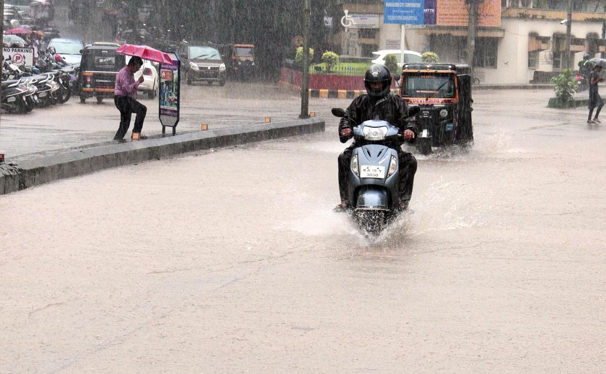 Vehicles wade through the flooded road near City Hospital in Mangaluru on Friday.
