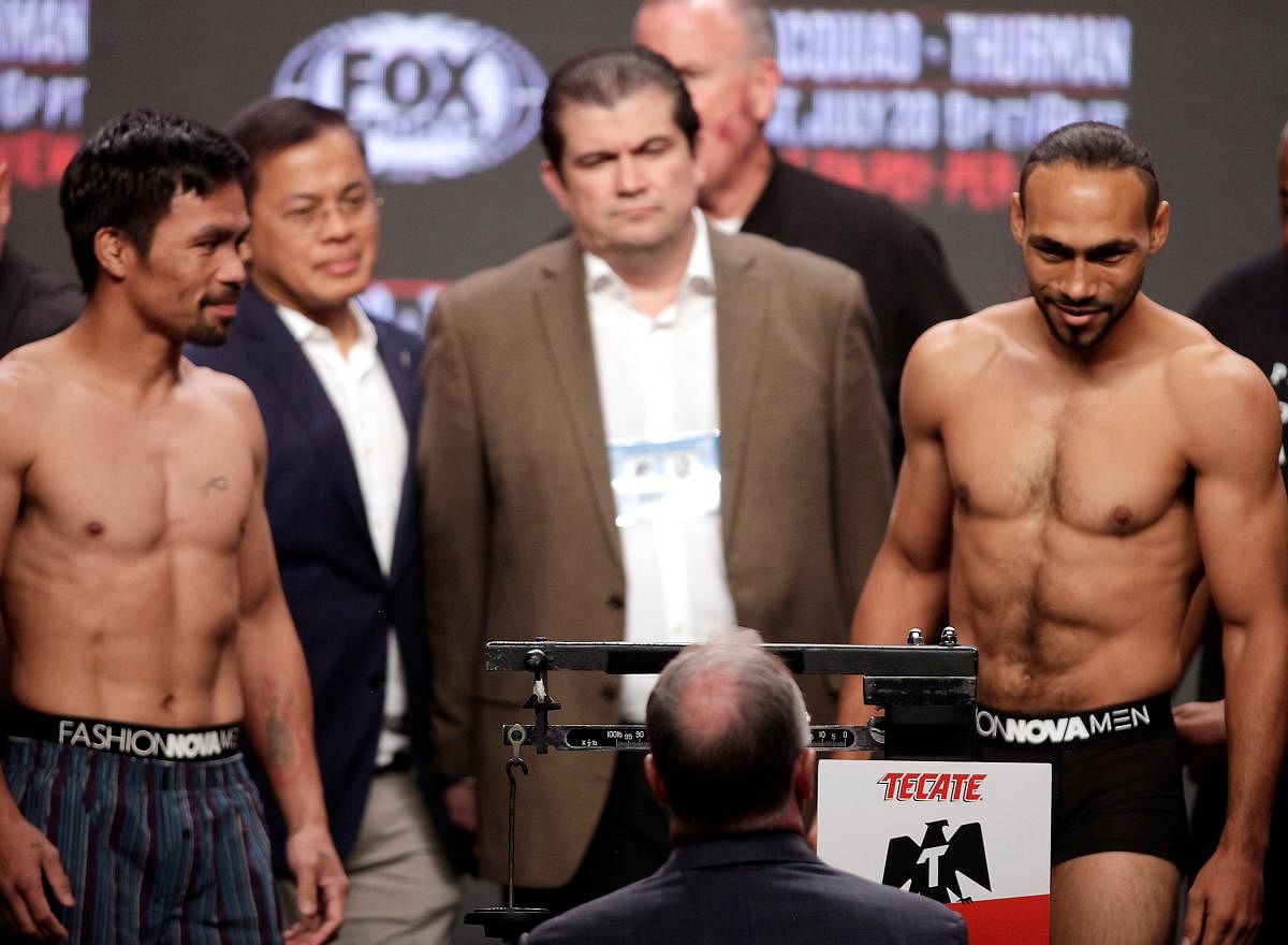 Boxers Manny Pacquiao (L) from the Philippines and Keith Thurman (R) from the USA face off during their weigh-in on July 19, 2019, at the MGM Grand Hotel and Casino in Las Vegas, Nevada. - The fighters will meet on July 20th in a WBA super world welterwei
