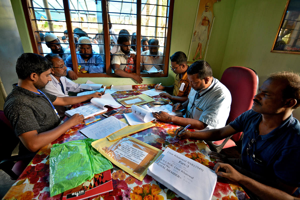 People wait to check their names on the draft list at the National Register of Citizens (NRC) centre at a village in Nagaon district in Assam on July 30, 2018. REUTERS File Photo