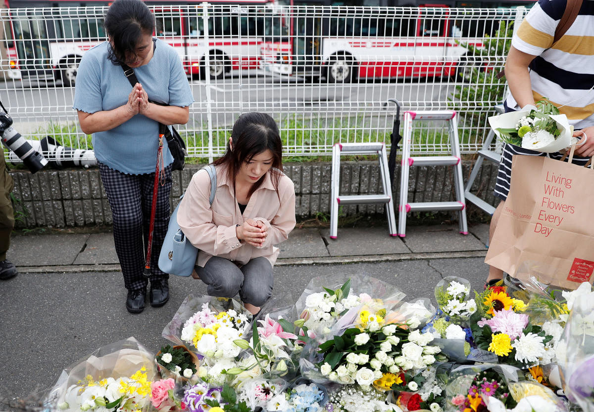 Women pray outside the Kyoto Animation building which was torched by arson attack, in Kyoto, Japan, July 19, 2019. REUTERS/Kim Kyung-Hoon
