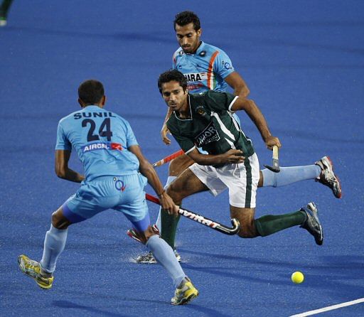 Pakistan's Ahmed Fareed, center, battles for the ball with India's Sowmarpet Vitalacharya Sunil, left, during Sultan Azlan Shah Cup men's field hockey tournament in Ipoh, Malaysia, Thursday, May 31, 2012. (AP Photo/ Vincent Thian)