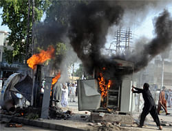 Pakistani Muslim demonstrators vandalise machinery during a protest against an anti-Islam film in Peshawar on September 21, 2012. At least 13 people died and nearly 200 were wounded in Pakistan during violent protests on Friday condemning a US-made film insulting Islam, defying a government call for only peaceful demonstrations, officials said. AFP PHOTO