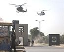 Military helicopters fly over the entrance to Pak army headquarters after an attack by armed men in Rawalpindi on Saturday. Reuters