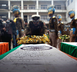 A paramilitary officer lays a wreath on the coffin of his colleague at the police headquarters in Srinagar, India, Thursday, March 14, 2013. Two militants carrying guns and grenades attacked a group of paramilitary soldiers on the outskirts of the capital of Indian-controlled Kashmir on Wednesday morning, leaving five soldiers and both militants dead and 10 other people wounded, police said. It was the bloodiest militant attack in the capital in years. (AP Photo