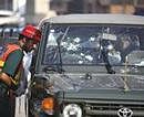 An emergency personnel checks an army jeep with bullet holes splattered on the windshield after it was attacked by gunmen in Islamabad on Thursday. AP