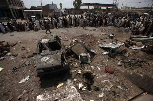 Residents and security officials gather at the site of a bomb attack in the outskirts of Peshawar. Reuters file photo
