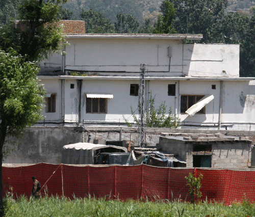 FILE - In this May 2, 2011 file photo, a Pakistani soldier stands near a compound where al-Qaida leader Osama bin Laden lived in Abbottabad, Pakistan. Bin Laden was able to live in Pakistan undetected for nine years because of a breathtaking scale of negligence and incompetence at practically all levels of the Pakistani government, according to an official government report published by the pan-Arab Al-Jazeera satellite channel on Monday, July 8, 2013. AP Photo