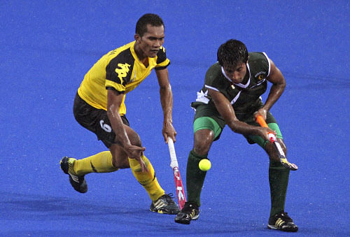 Pakistan's Muhammad Tousiq, right, and Malaysia's Muhammad Marhan Mohd Jalil battle for the ball during their 3rd and 4th placed match of the 9th men's Asia Cup field hockey tournament in Ipoh, Malaysia, Sunday, Sept. 1, 2013. (AP Photo)