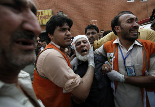 A man (C) cries over the death of his son, who was killed in a bomb blast, at a hospital in Peshawar September 29, 2013. Twin blasts in the northwestern Pakistan city of Peshawar killed 33 people and wounded 70 on Sunday, a week after two bombings at a church in the frontier city killed scores, police and hospital authorities said.REUTERS