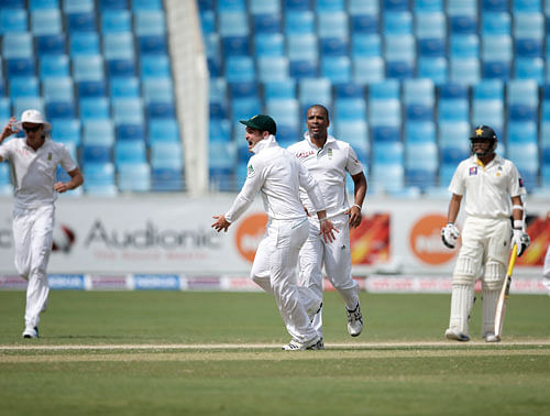 South Africa's Dean Elgar, center left, and Vernon Philander, center right, celebrate as taking the wicket of Pakistan's Khurram Manzoor during the third day of the second cricket test match of a two match series between Pakistan and South Africa at the Dubai International Cricket Stadium in Dubai, United Arab Emirates, Friday, Oct. 25, 2013. AP Photo