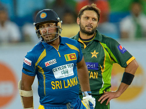Kumar Sangakkara, left, and Pakistan bowler Shahid Afridi, right, during the first T20 cricket match between Pakistan and Sri Lanka, at the DSC Cricket Stadium Dubai, United Arab Emirates, Wednesday, Dec. 11, 2013. AP Photo