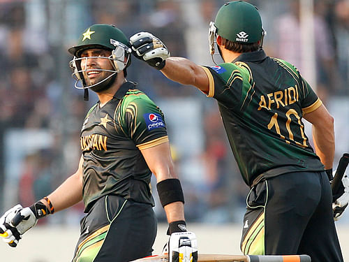 Pakistan's Umar Akmal leaves the field after being dismissed as teammate Shahid Afridi congratulates him during their ICC Twenty20 World Cup match against Australia at the Sher-E-Bangla National Cricket Stadium in Dhaka. Reuters