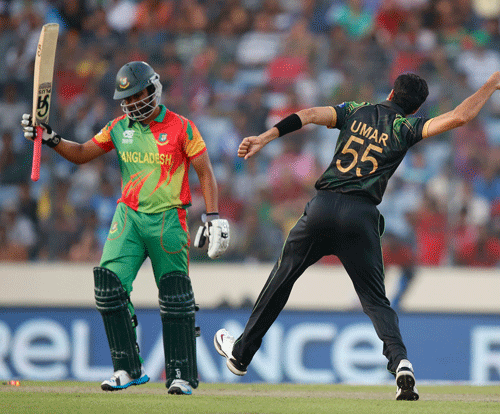 Pakistan bowler Umar Gul, right, celebrates after taking the wicket of Bangladesh batsman Tamim Iqbal, left, during their ICC Twenty20 Cricket World Cup match in Dhaka, Bangladesh, Sunday, March 30, 2014. (AP Photo/Aijaz Rahi)