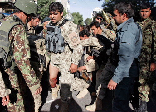 A wounded Afghanistan's National Army (ANA) soldier, center, receives treatment from his colleagues at the site of a clash between insurgents and security forces over Indian Consulate in Herat, Afghanistan, Friday, May 23, 2014. Gunmen armed with machine guns and rocket-propelled grenades attacked the Indian Consulate in western Afghanistan's Herat province Friday, an assault that injured no diplomatic staff, police said. Indian officials said there had been a threat against its diplomats in Afghanistan, but gave no other details.  AP