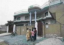Children play in front of a house where police reportedly arrested five US Muslims in Sargodha, Pakistan. AP
