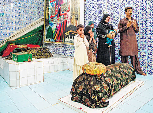 Uncertain times: A family praying last week in Karachi at the shrine of Abdullah Shah Ghazi, a Sufi saint.  NYT