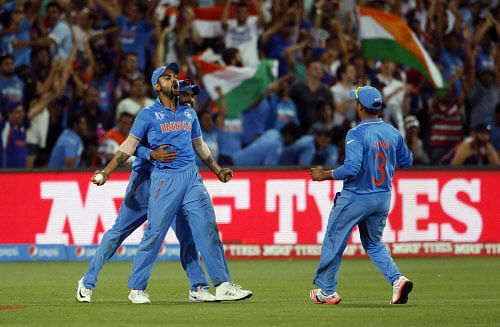 India's Virat Kohli (L) celebrates his catch, dismissing Pakistan's batsman Shahid Afridi during their Cricket World Cup match in Adelaide, February 15, 2015. REUTERS/