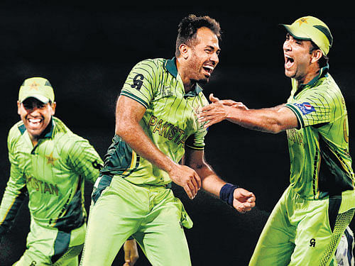 key man Pakistan's Wahab Riaz (centre) celebrates a Zimbabwe wicket with  team-mates at Brisbane on Sunday. Pakistan won the match by 20 runs. reuters