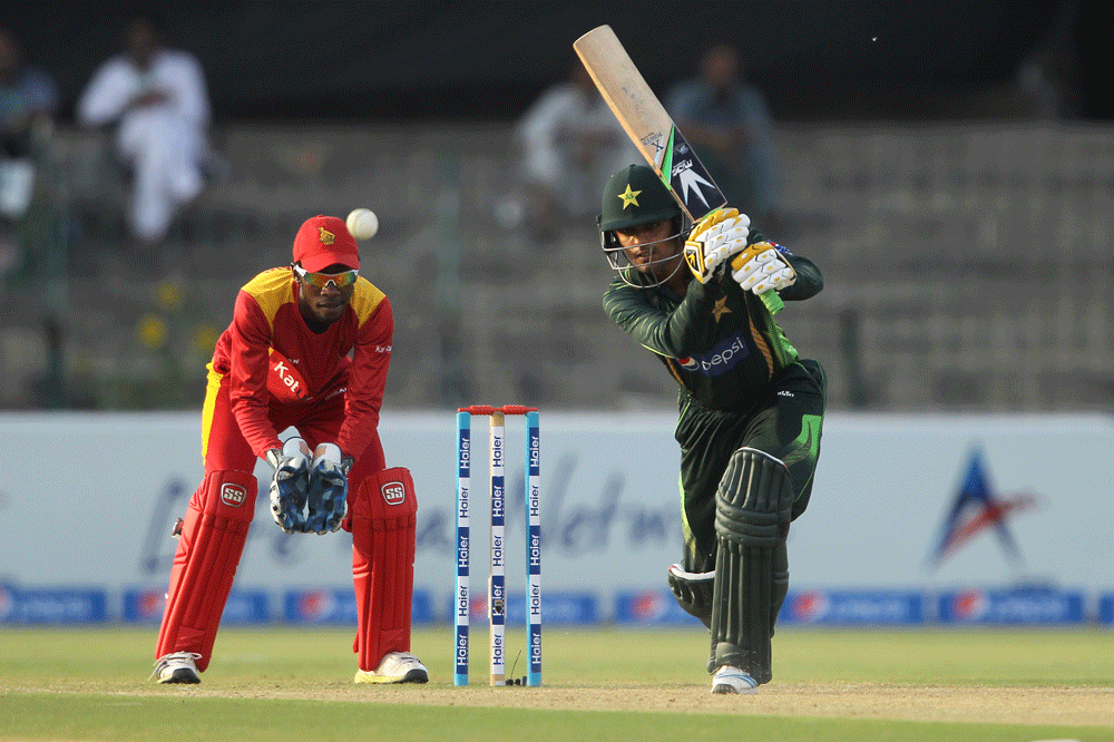 Pakistan's Baber Azam, right, plays a shot as Zimbabwe wicketkeeper Richmond Mutumbami, follows AP