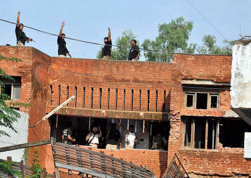 Security personnel show the victory sign after an encounter with armed militants in Dinanagar, Gurdaspur on Monday. PTI Photo