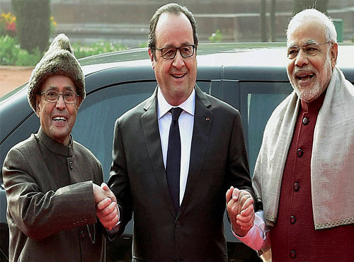 French President Francois Hollande (C) joins hands with President Pranab Mukherjee and Prime Minister Narendra Modi (R) during his ceremonial welcome at Rashtrapati Bhavan in New Delhi on Monday. PTI Photo