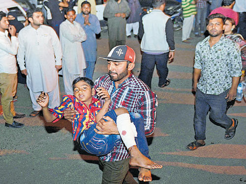 A man carries an injured boy in Lahore on Sunday. AFP